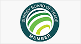 A green and white logo for the surrey board of trade.